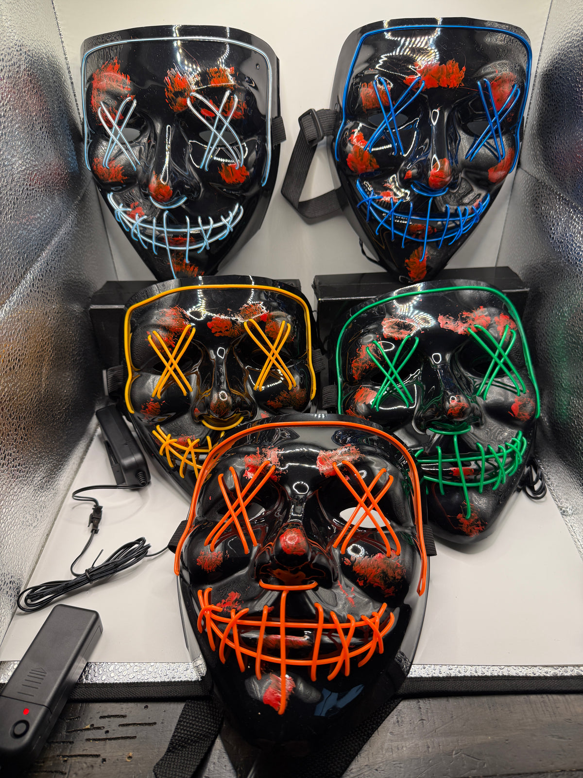 Five black LED light-up scary masks with different colored LED wiring