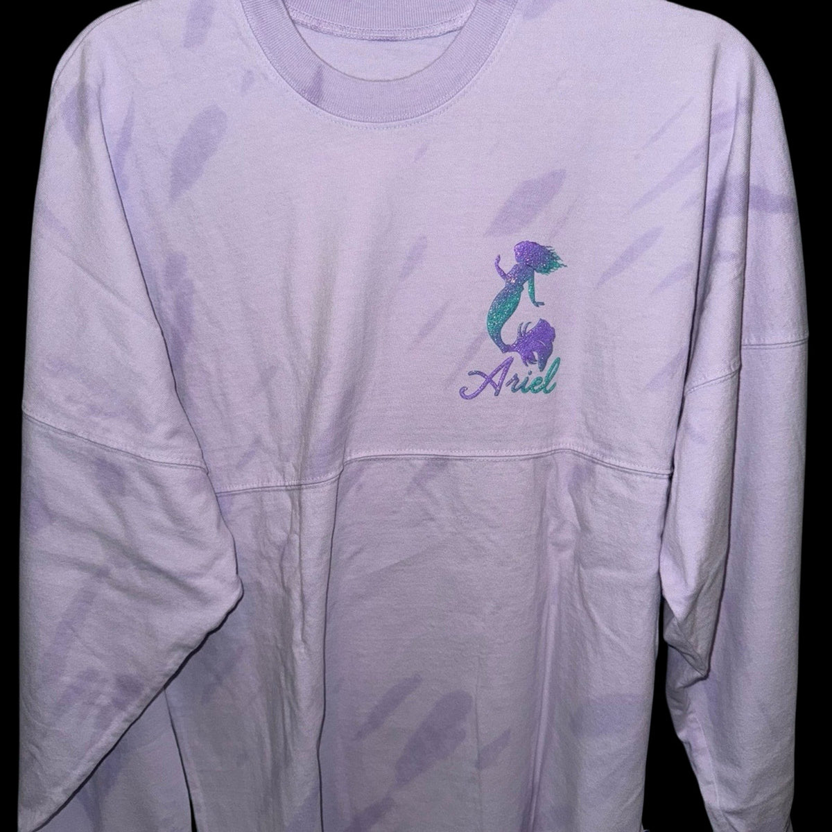 Marketplace239 LLC Disney Ariel Spirit Jersey in light purple tie-dye with a glittery Ariel silhouette on the chest.