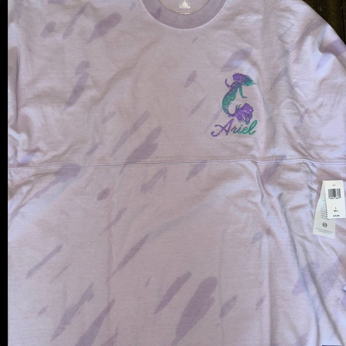 Marketplace239 LLC Disney Ariel Spirit Jersey in light purple tie-dye with a glittery Ariel logo on the chest.